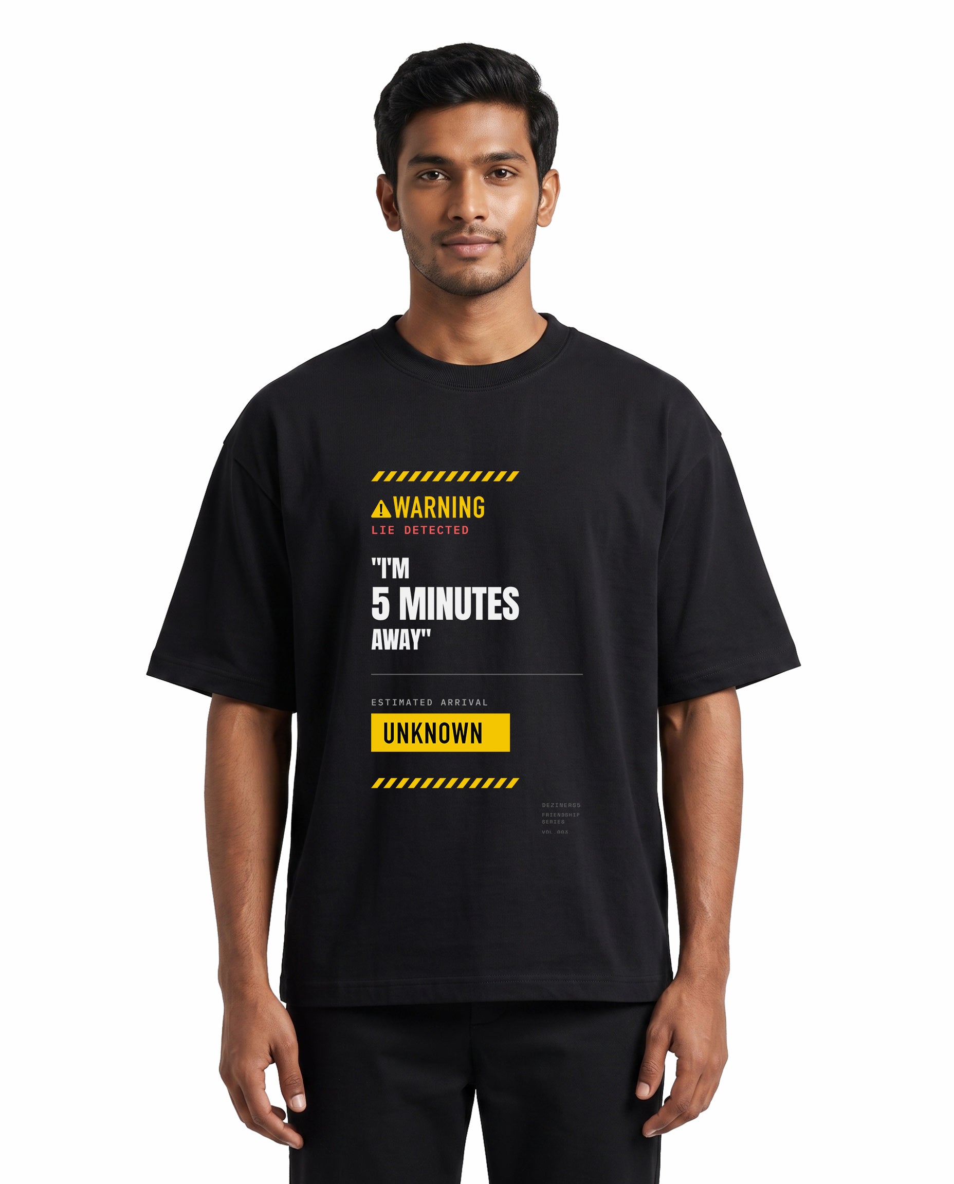 Front view of male model wearing 5 MINS AWAY unisex oversized graphic t-shirt in black in a studio setting.