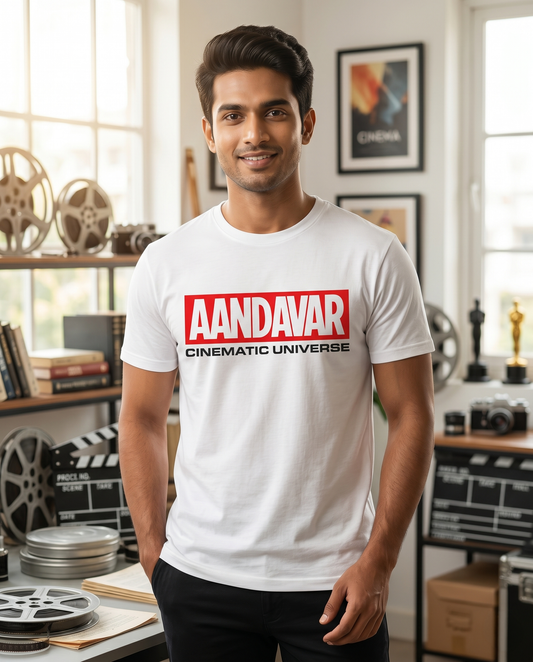 Young South Indian male wearing the AANDAVAR CINEMATIC UNIVERSE men's regular-fit t-shirt in white inside a premium cinema collector's studio.