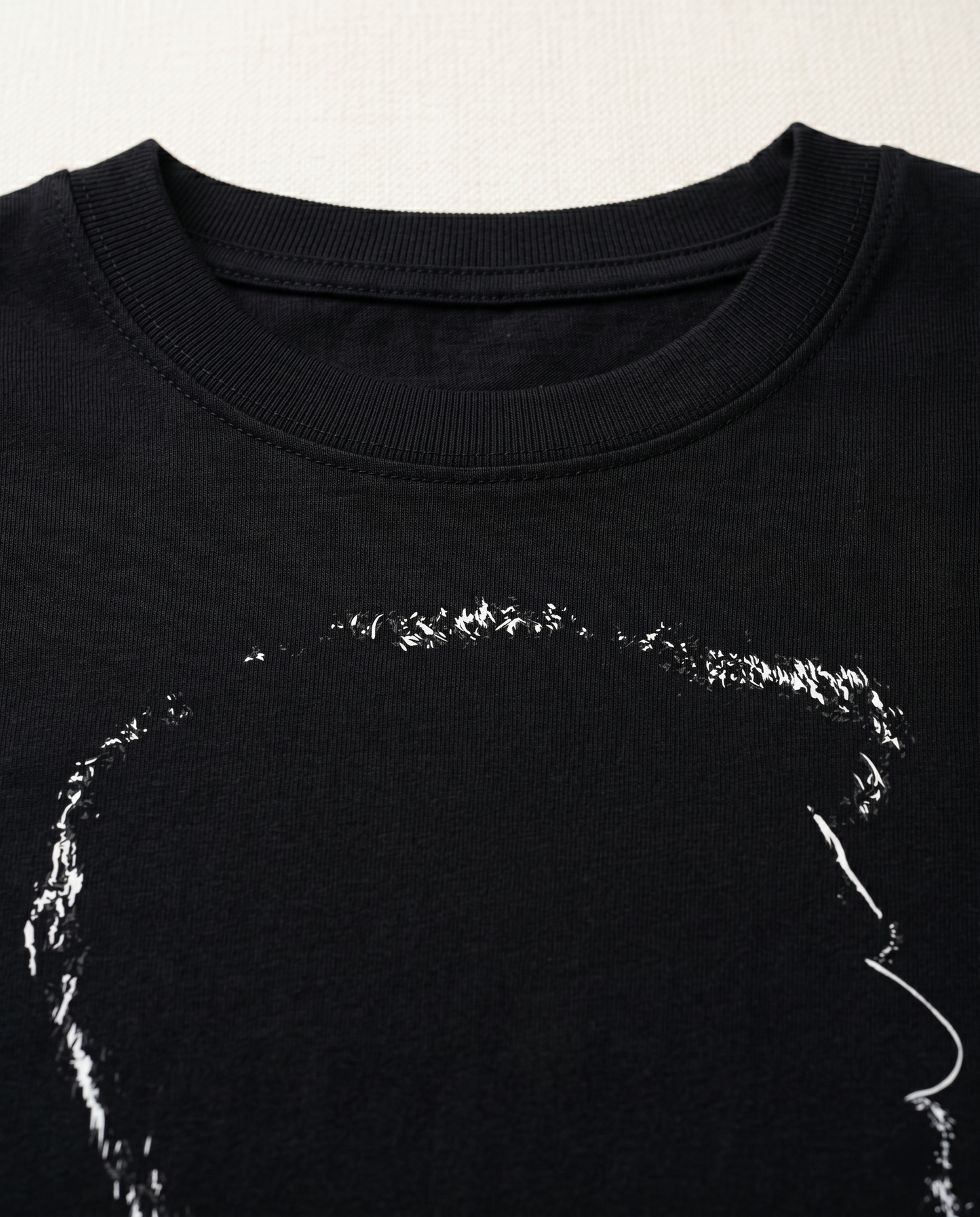 Close-up view of the ACHAMILLAI graphic print highlighting premium print quality and illustration details on a black men's regular-fit t-shirt.