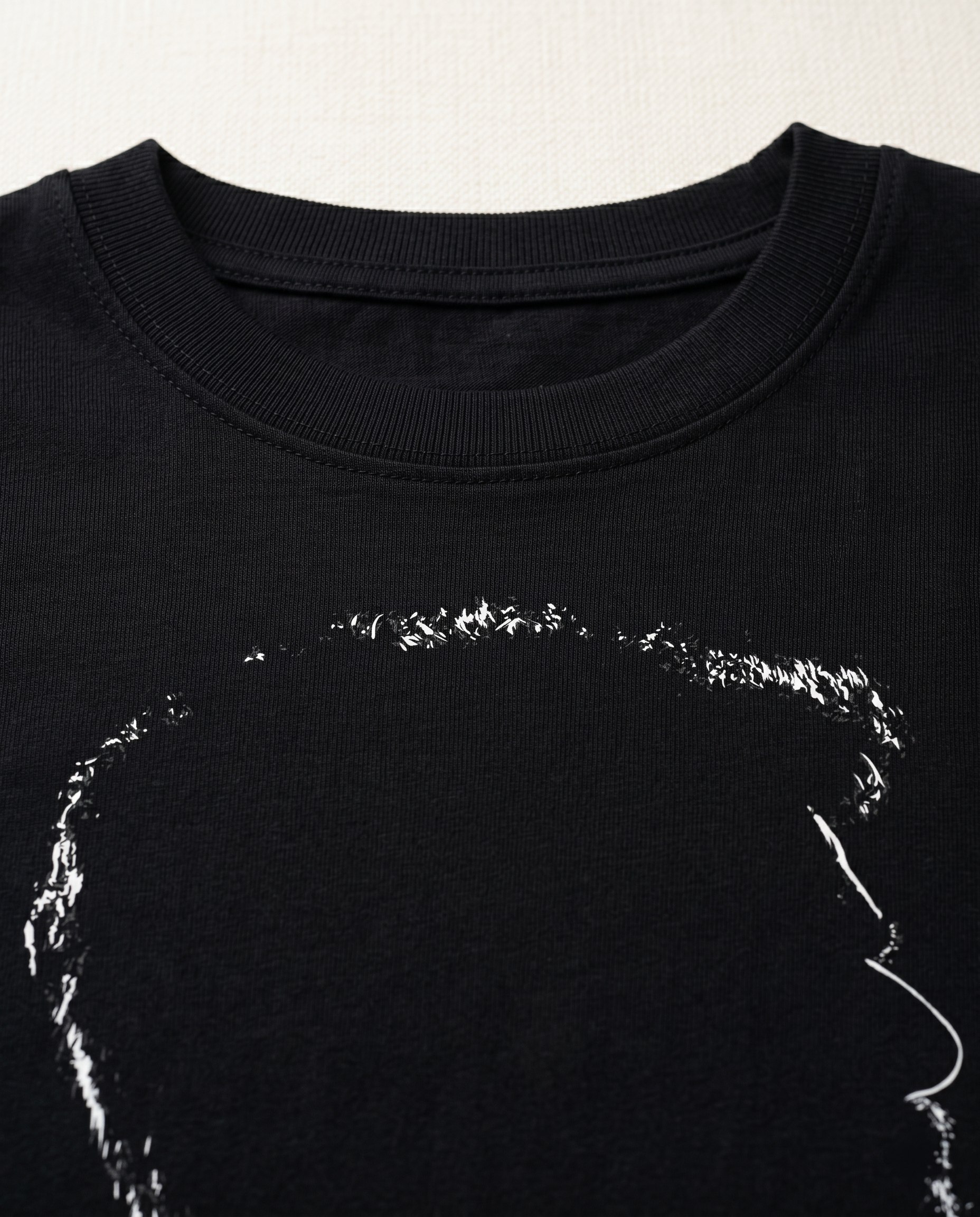 Close-up view of the ACHAMILLAI graphic print highlighting premium print quality and illustration details on a black men's regular-fit t-shirt.