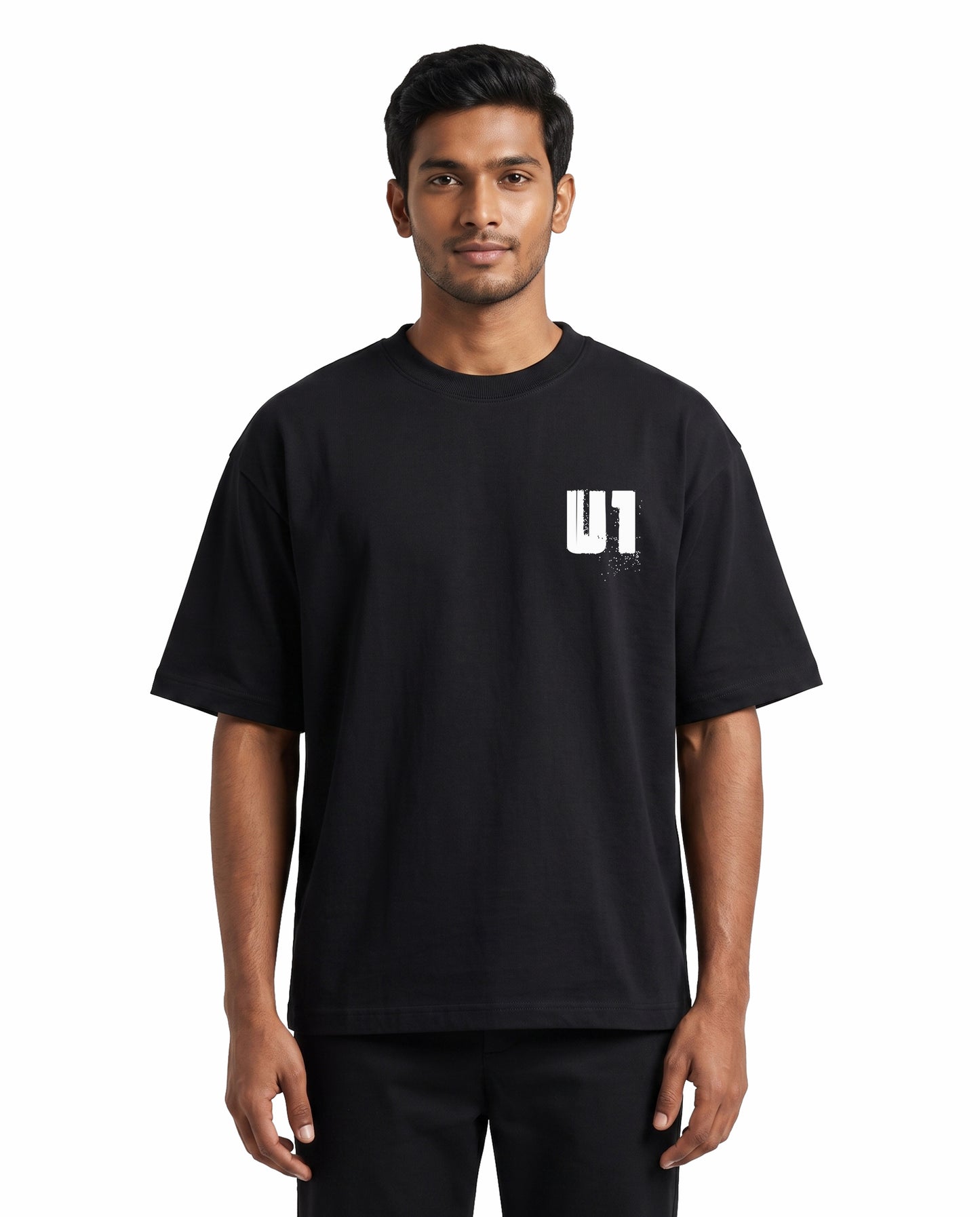 Front view of male model wearing ADDICTED TO U1 unisex oversized graphic t-shirt in black in a studio setting.
