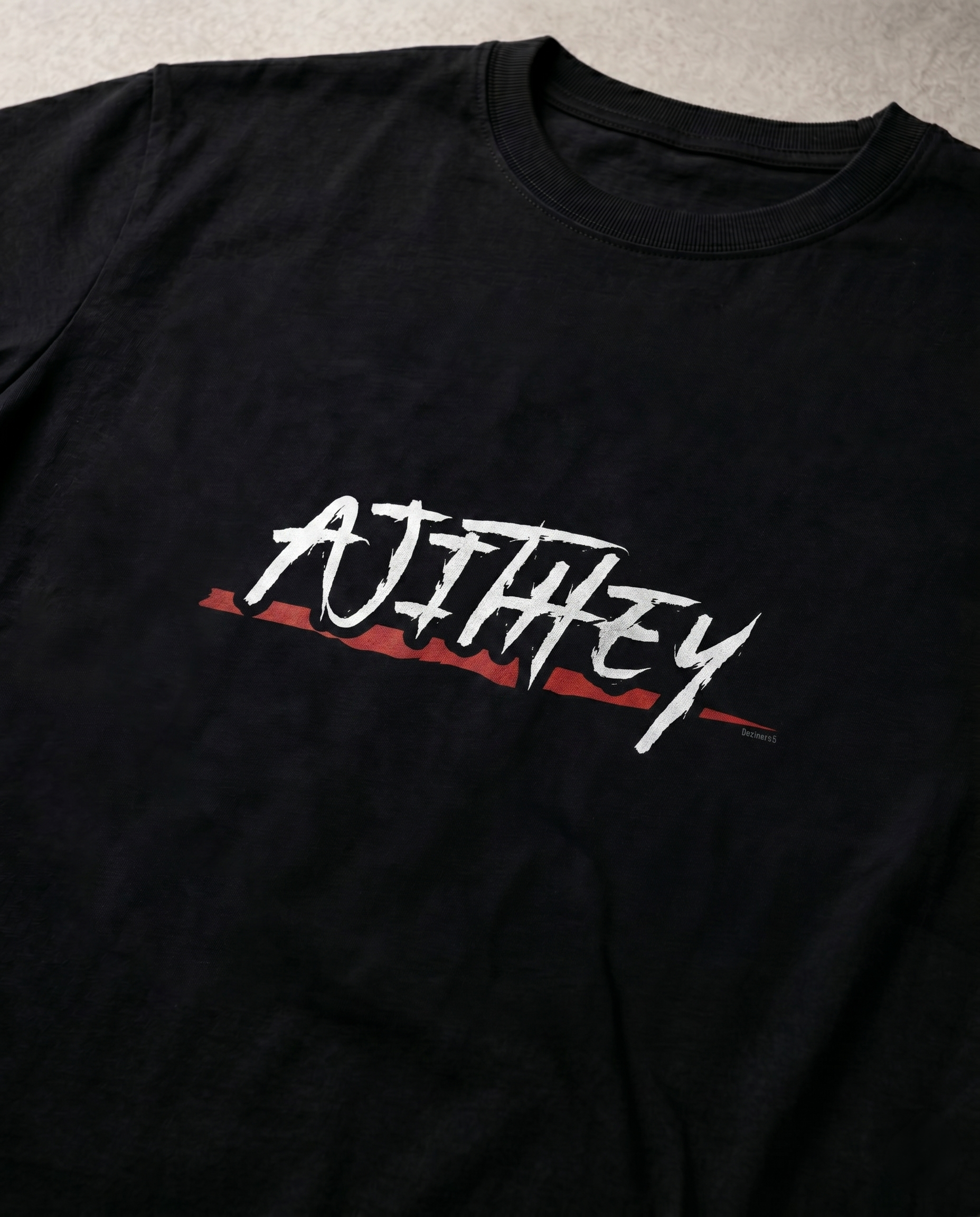 Close-up view of the AJITHEY front typography graphic print highlighting premium print quality and design details on a black men's regular-fit t-shirt.