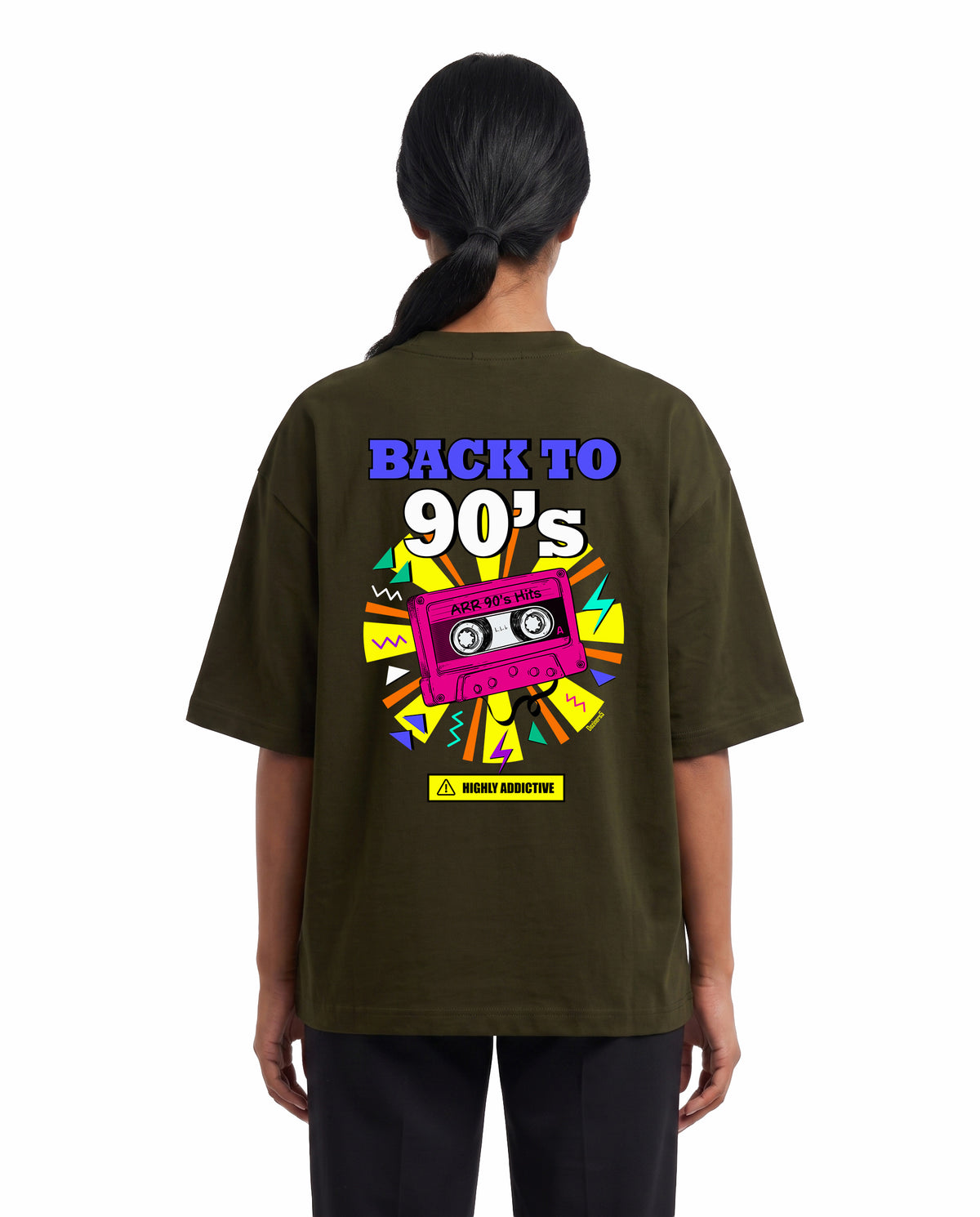Back view of female model wearing ARR 90S HITS - Unisex Oversized Graphic T-Shirt in olive green in a studio setting.