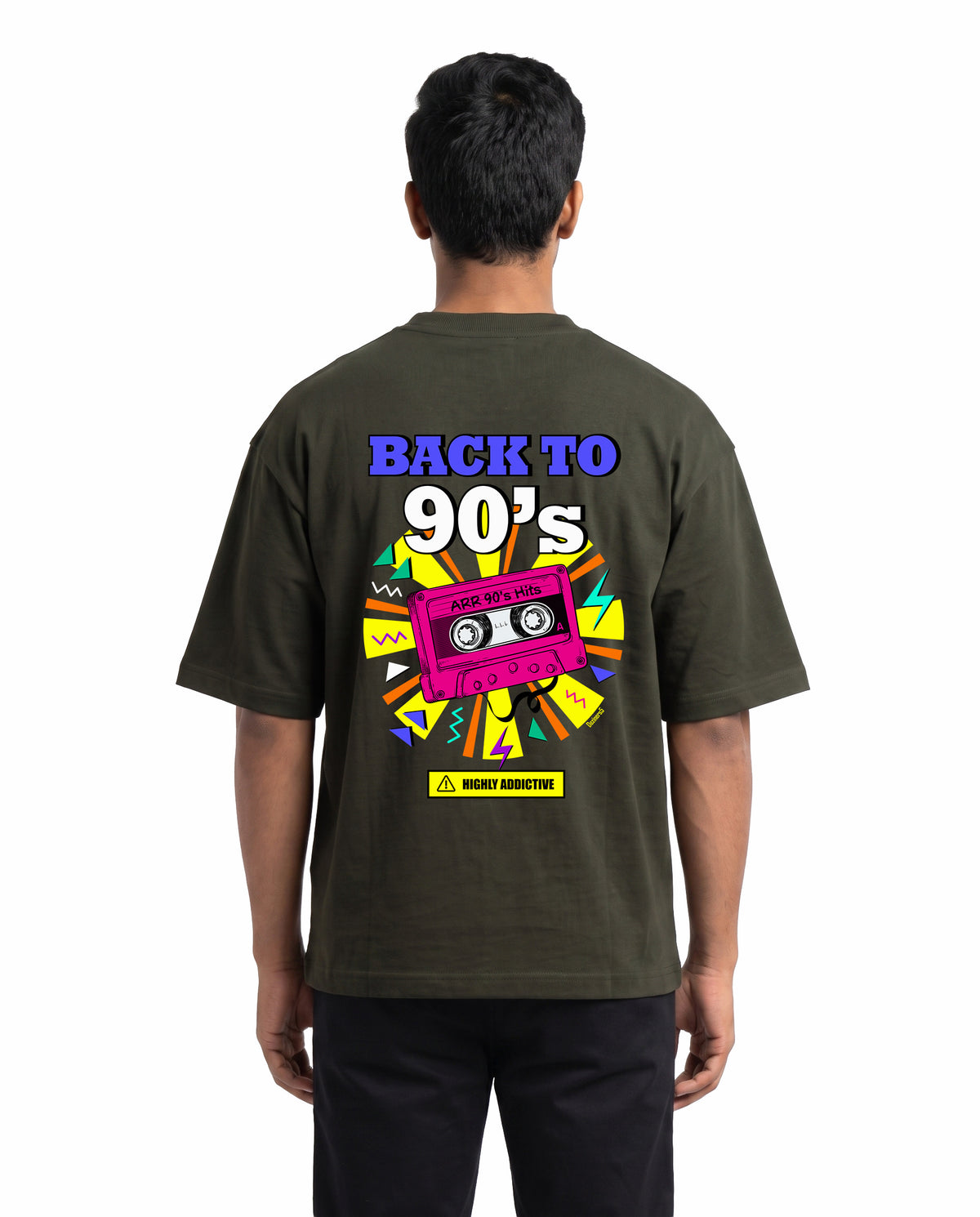 Back view of male model wearing ARR 90S HITS - Unisex Oversized Graphic T-Shirt in olive green in a studio setting.