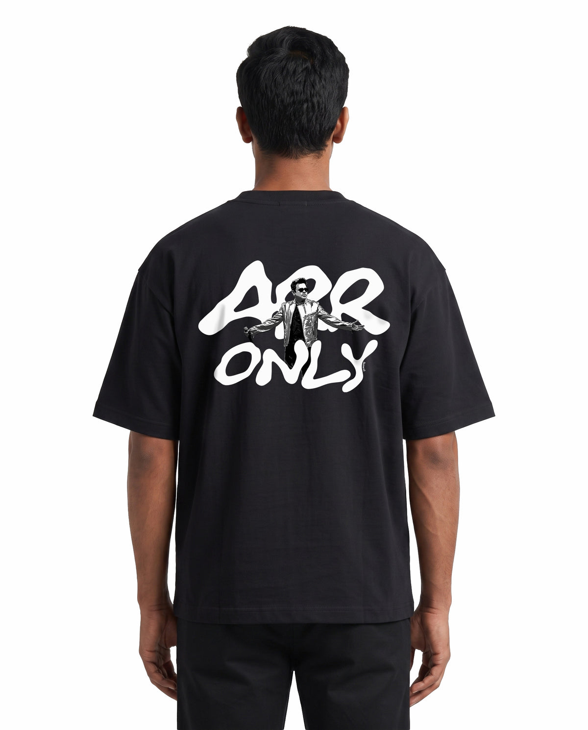 Back view of male model wearing ARR TRIBUTE - Unisex Oversized Graphic T-Shirt in black in a studio setting.
