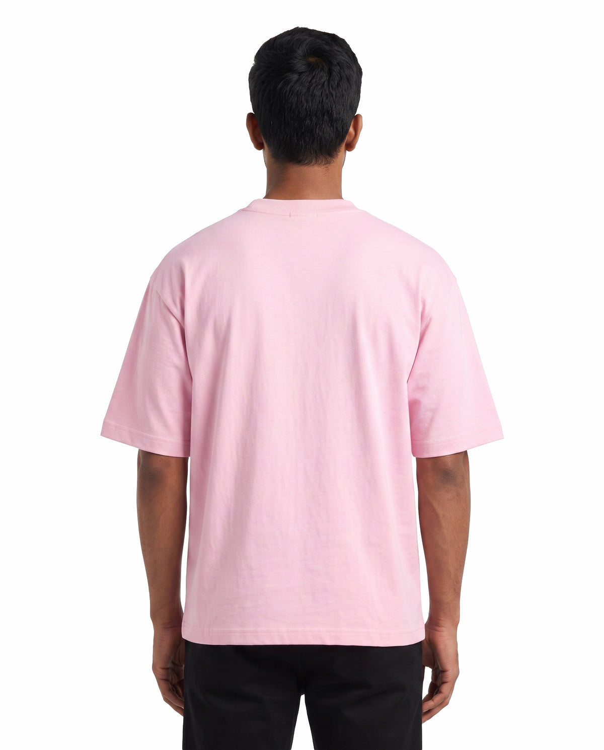 Back view of male model wearing ARR VIBES - Unisex Oversized Graphic T-Shirt in light baby pink in a studio setting.