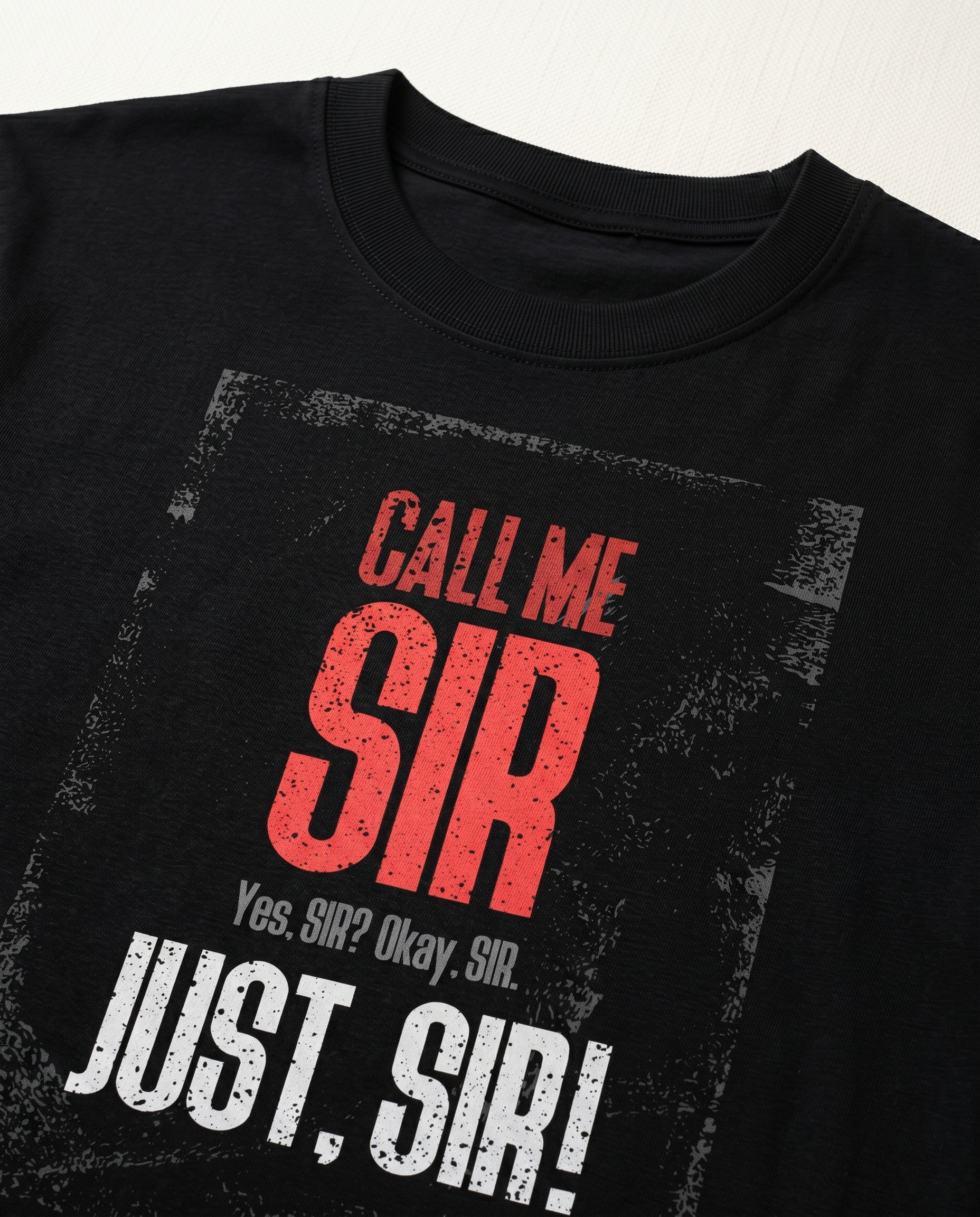 Detailed close-up of the CALL ME SIR front graphic print highlighting typography and premium print quality on a black men's regular-fit t-shirt.