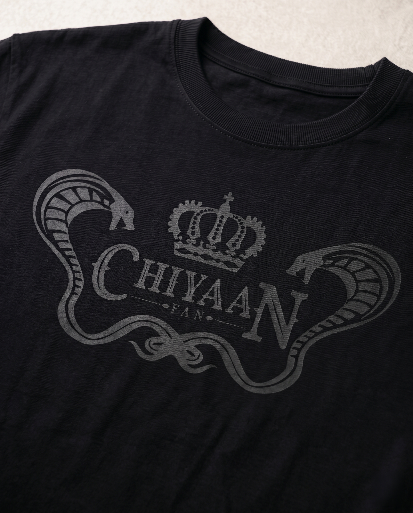 Close-up view of the CHIYAAN FAN graphic print highlighting typography details and premium print quality on a black men's regular-fit t-shirt.