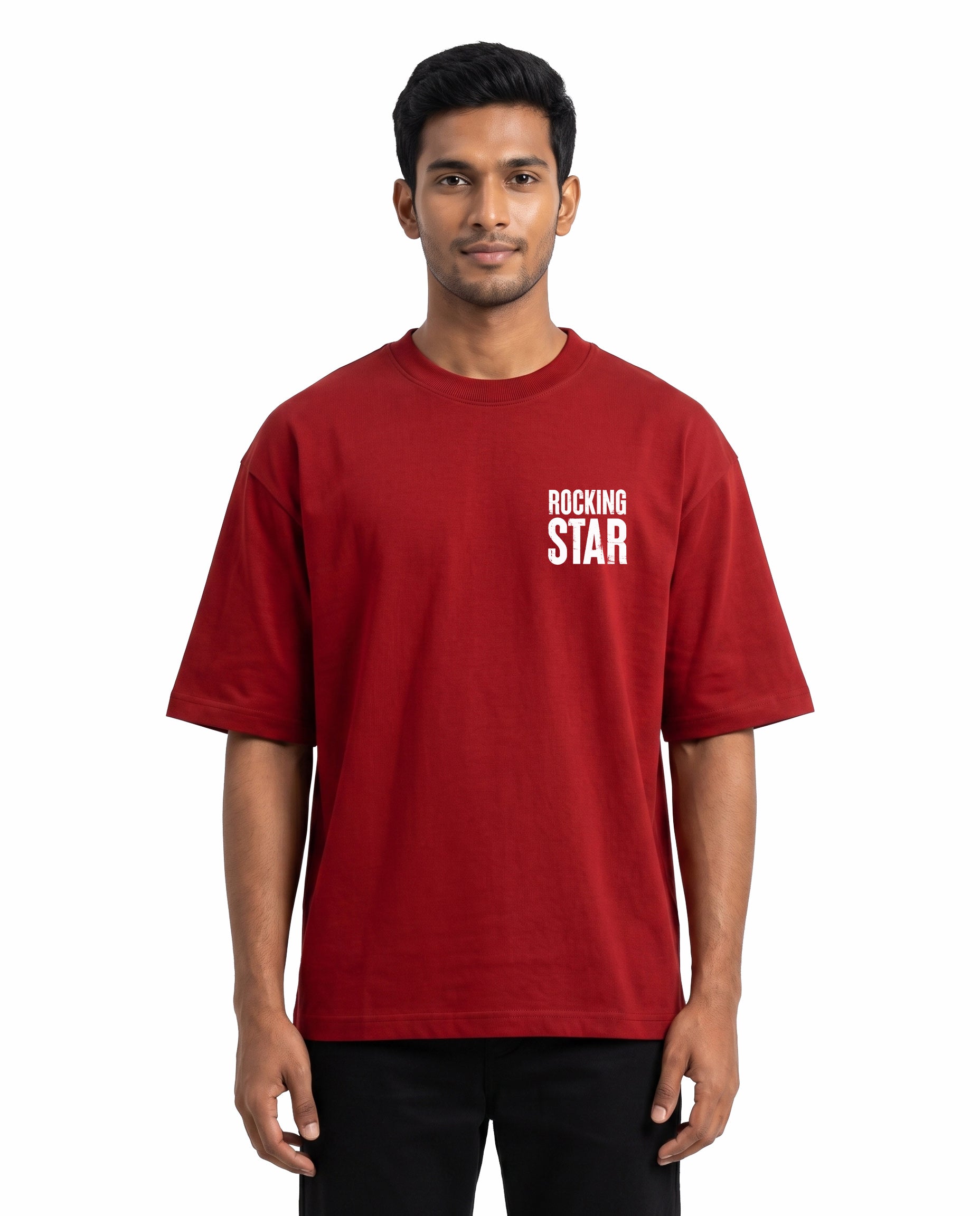Front view of male model wearing DADDY'S HOME unisex oversized graphic t-shirt in red in a studio setting.
