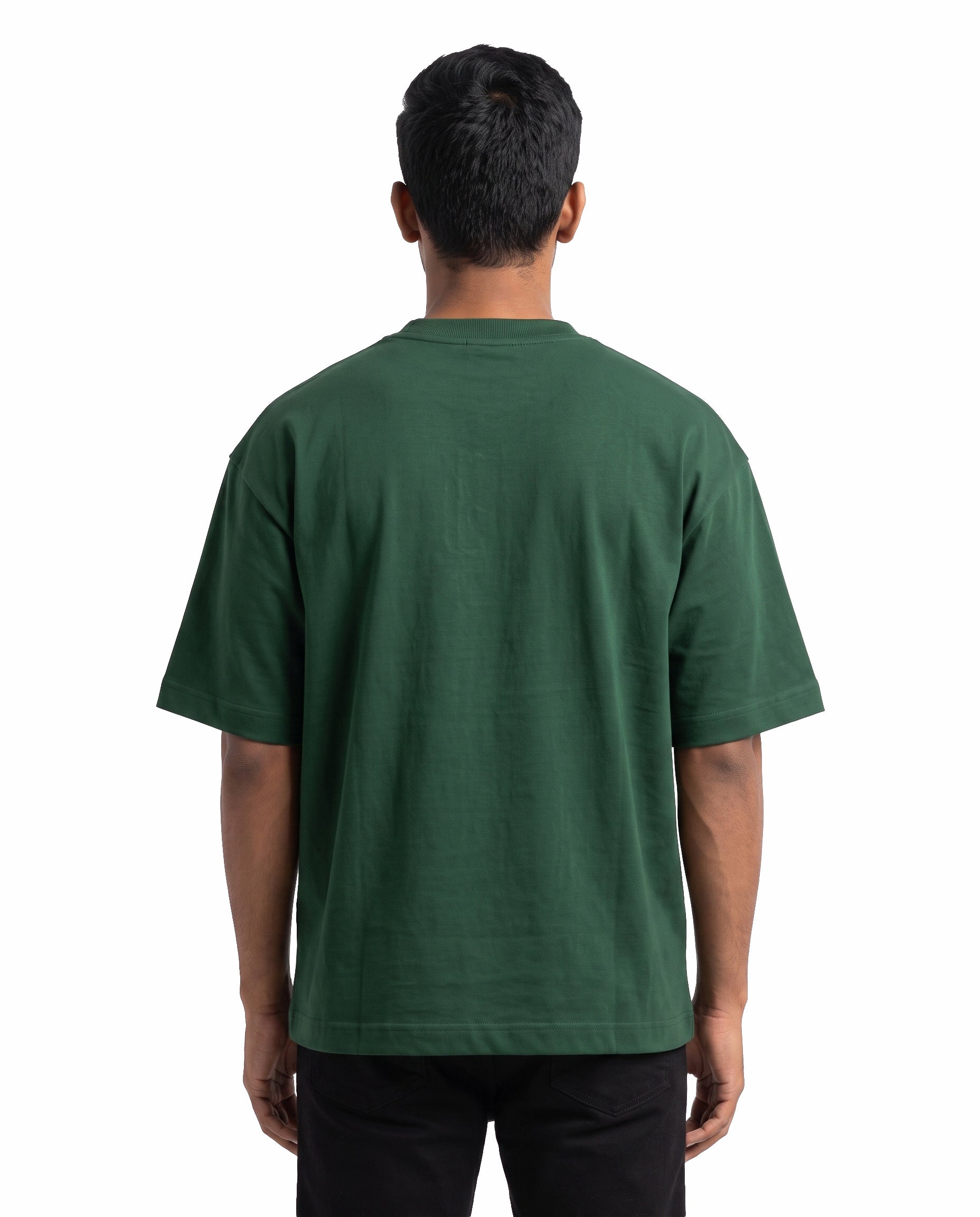 Back view of male model wearing EN FRIEND AH POLA YAARU MACHAN unisex oversized graphic t-shirt in bottle green in a studio setting.