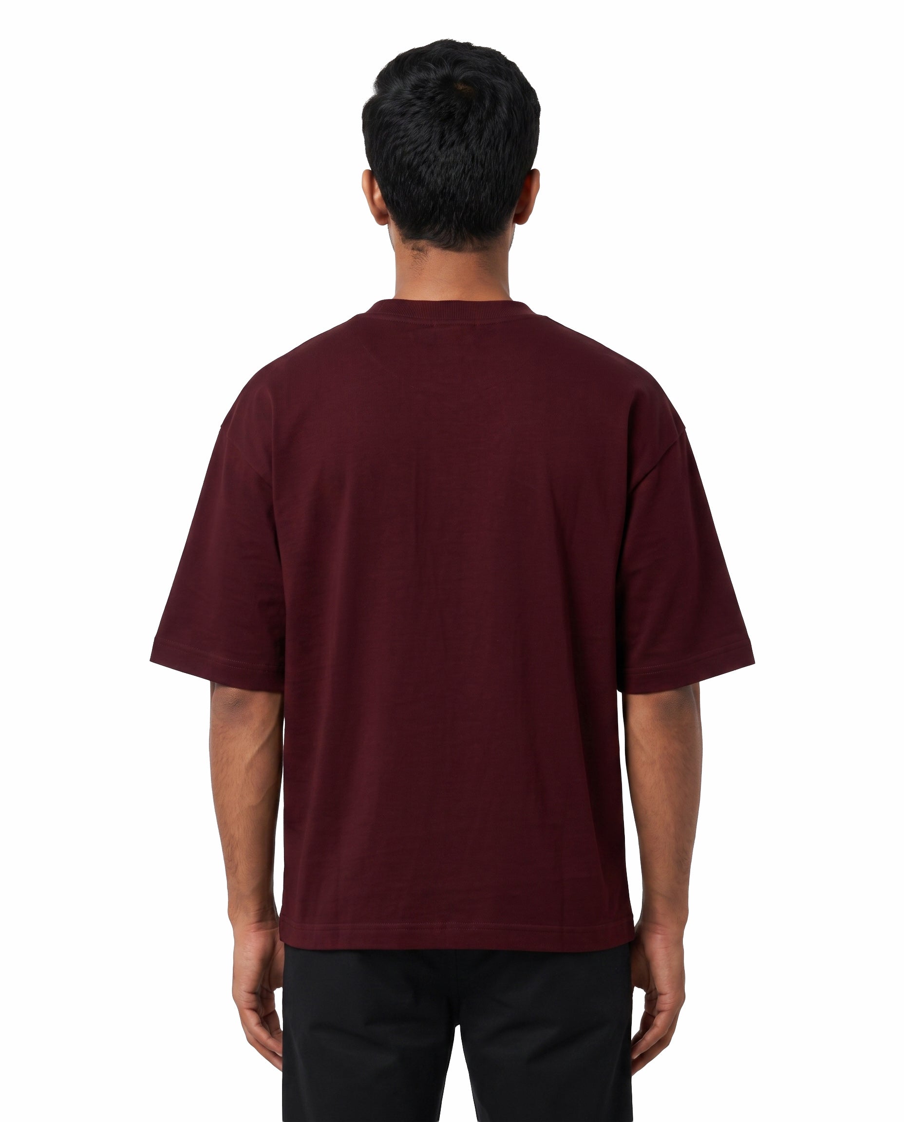 Back view of male model wearing EN FRIEND AH POLA YAARU MACHAN unisex oversized graphic t-shirt in maroon in a studio setting.