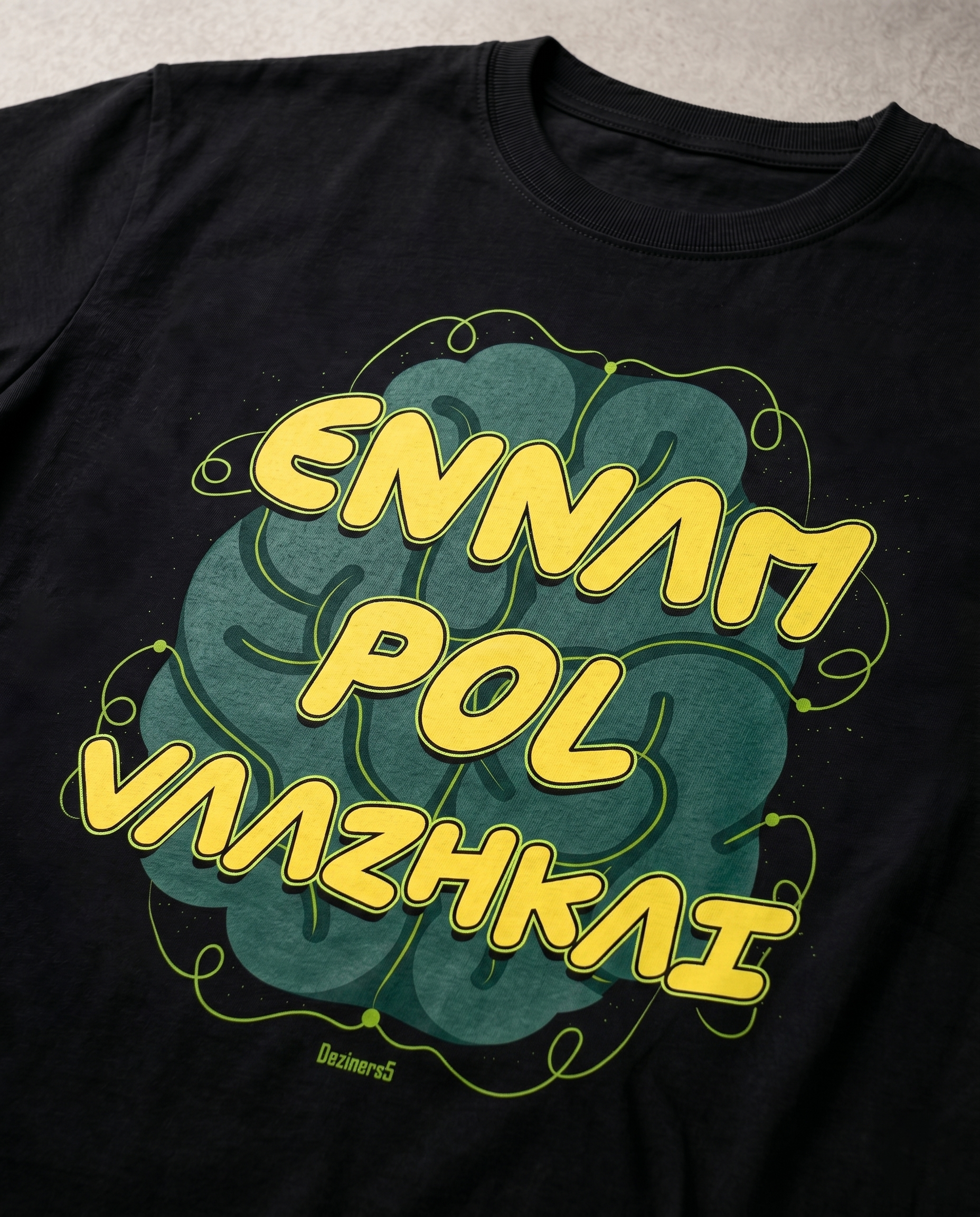 Close-up view of the ENNAM POL VAAZHKAI typography graphic print highlighting premium print quality and design details on a black men's regular-fit t-shirt.