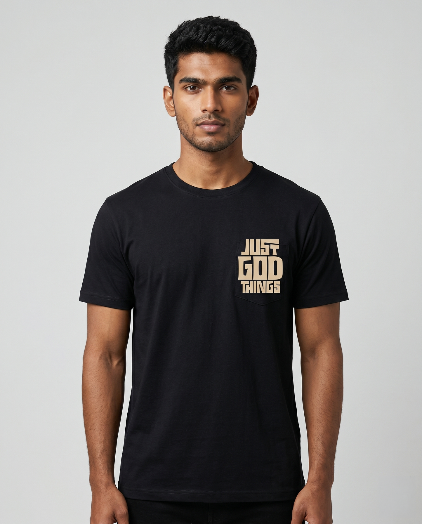 Young South Indian male model wearing JUST GOD THINGS men's regular fit black graphic t-shirt with chest print.