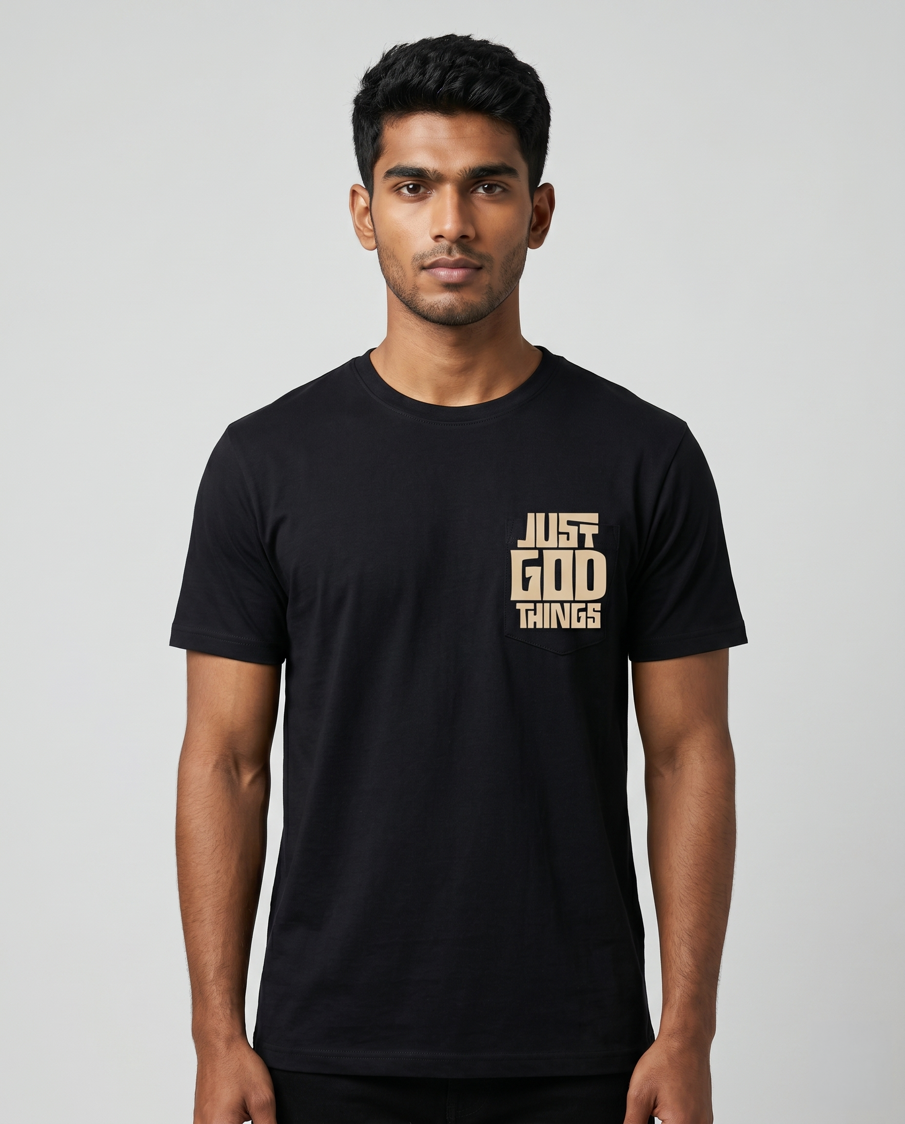 Young South Indian male model wearing JUST GOD THINGS men's regular fit black graphic t-shirt with chest print.