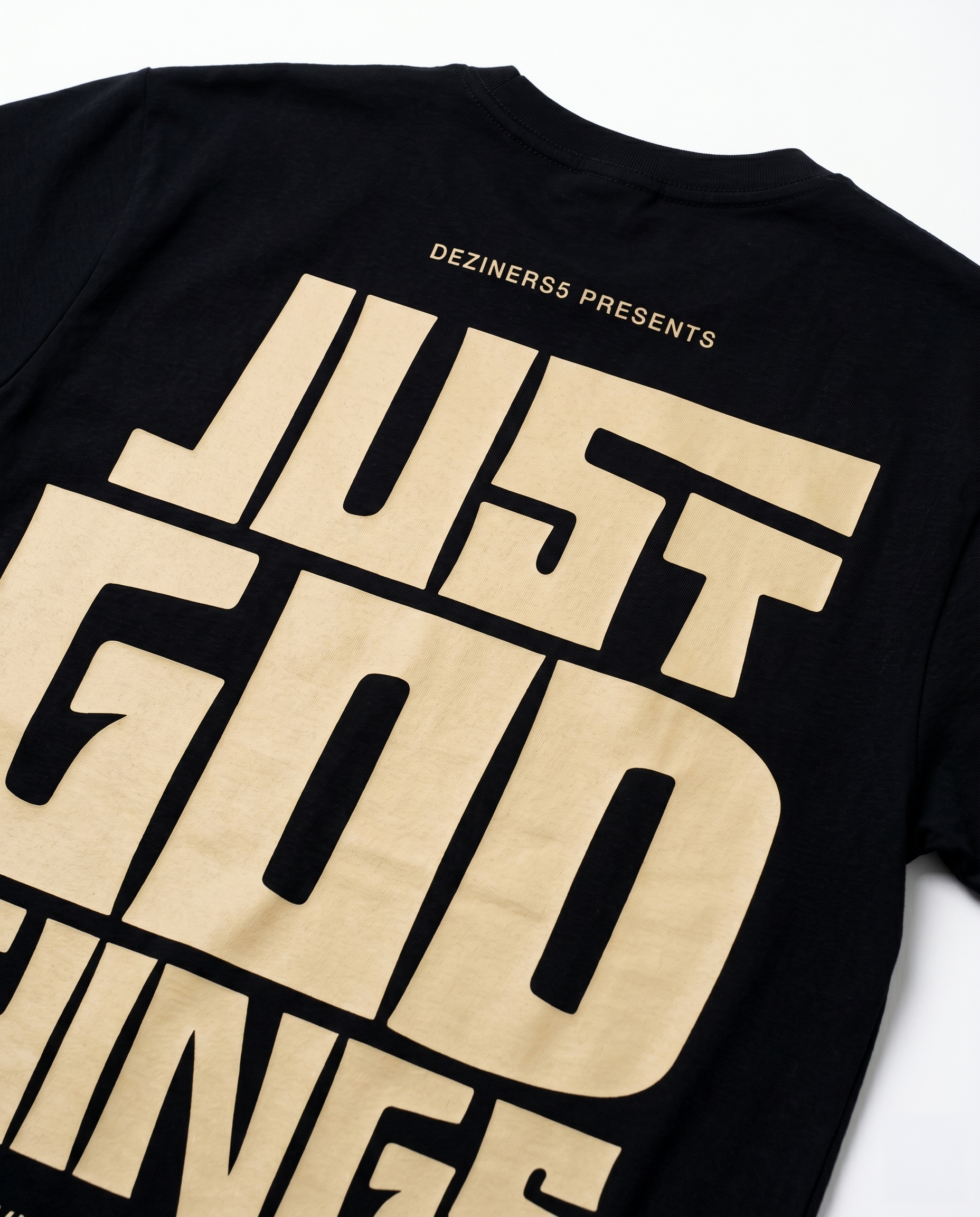 Close-up detail of JUST GOD THINGS graphic print on men's regular fit black cotton t-shirt.