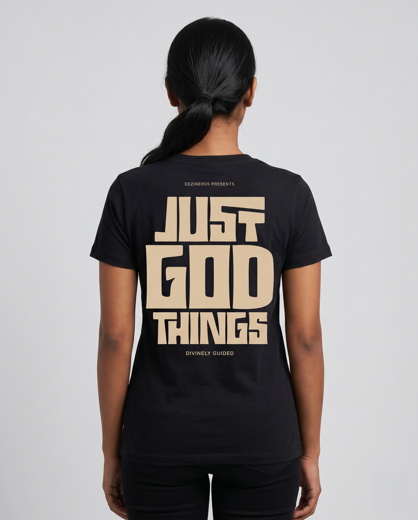Young South Indian female model wearing JUST GOD THINGS women's regular fit black graphic t-shirt with large back graphic.