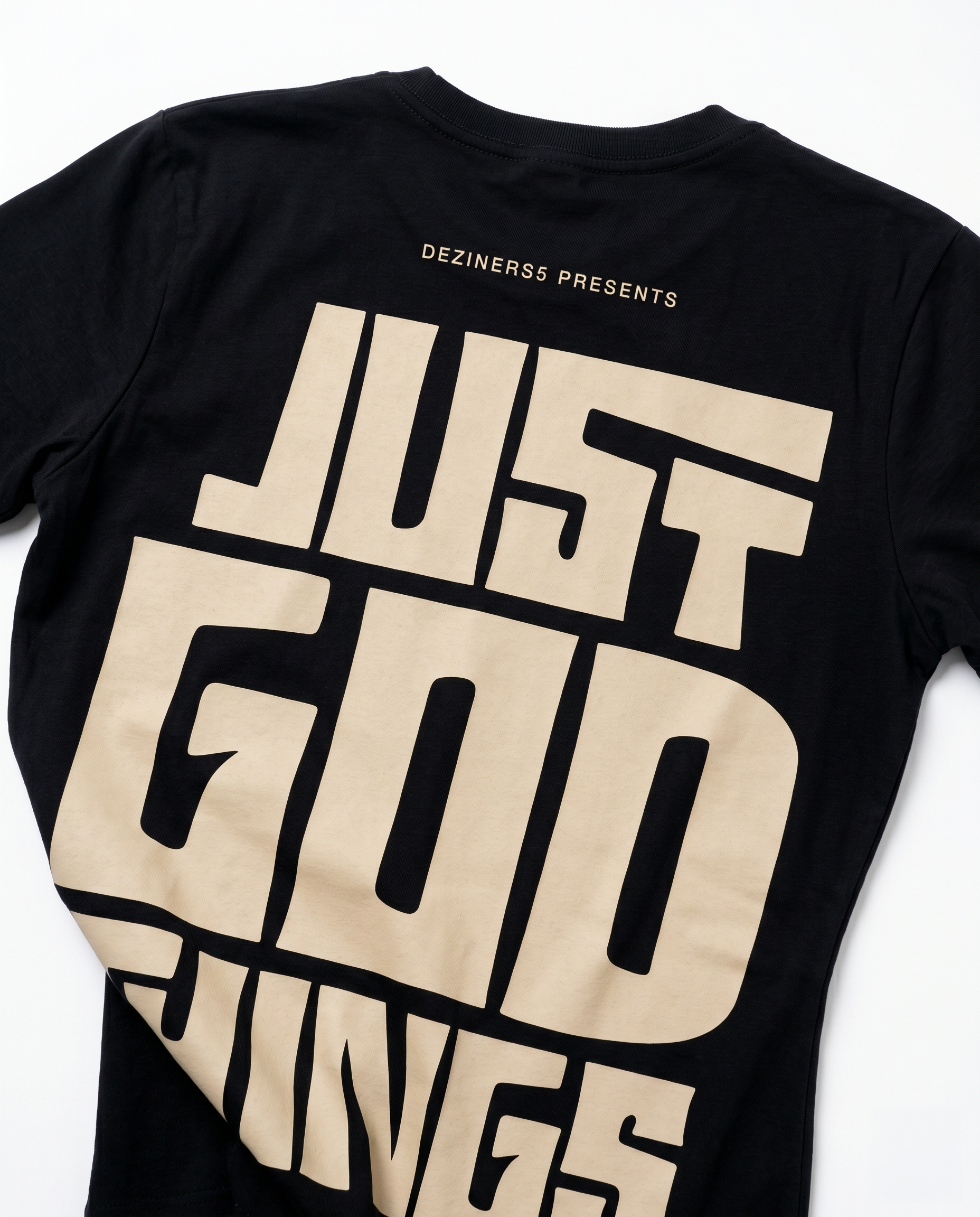 Close-up detail of JUST GOD THINGS graphic print on women's regular fit black cotton t-shirt.