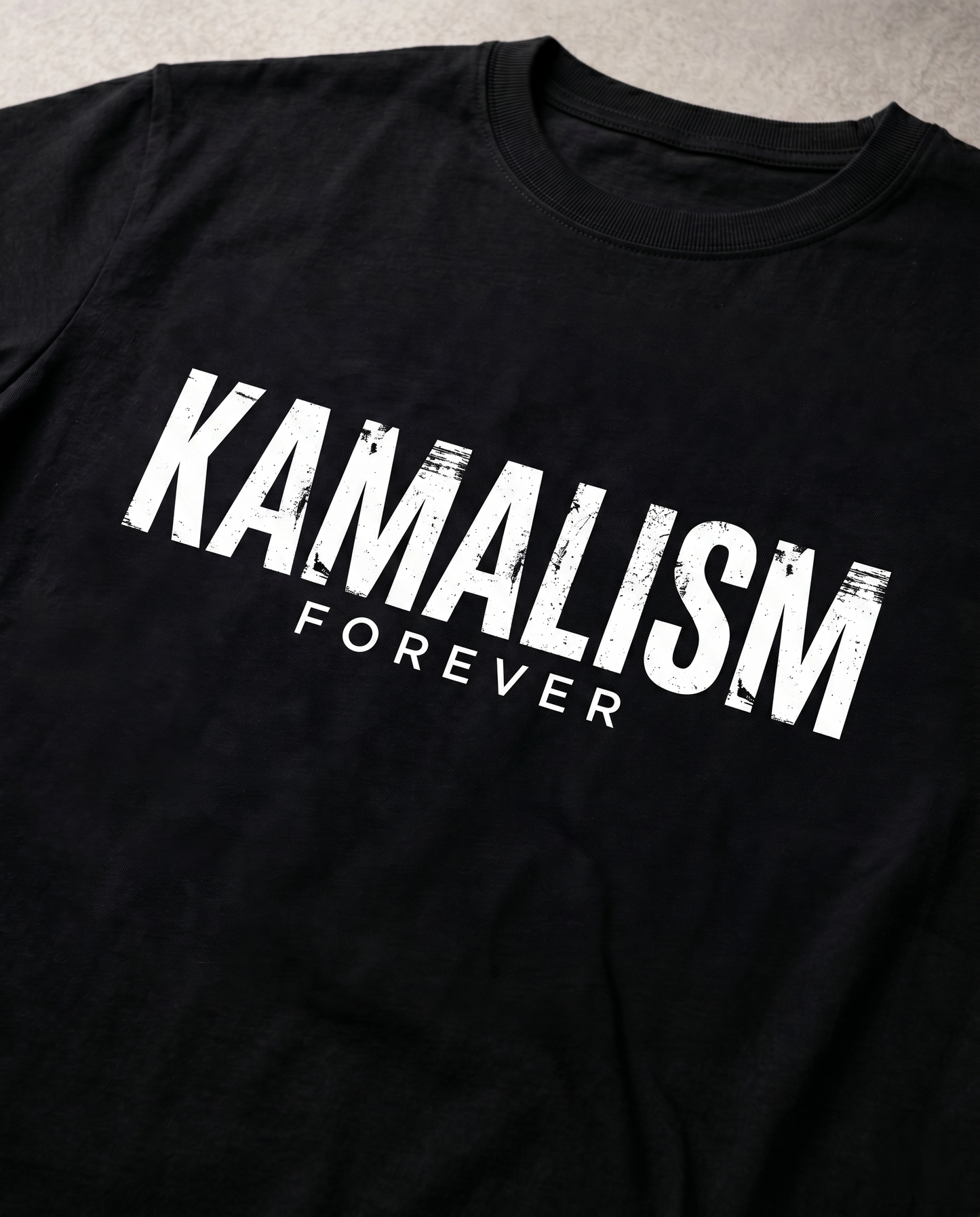Close-up view of the KAMALISM FOREVER front graphic print showcasing premium print quality and design details on a black men's regular-fit t-shirt.