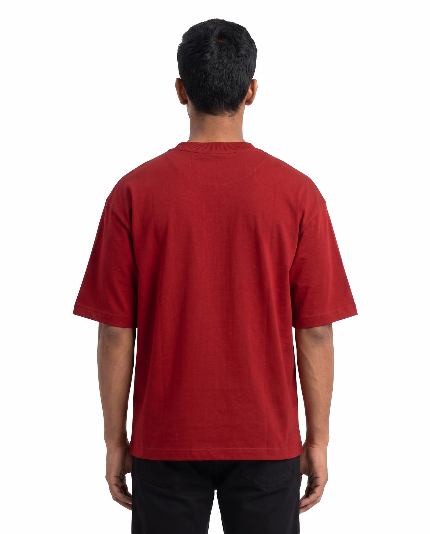 Back view of male model wearing NAAN VEEZHVENENDRU NINAITHAAIYO unisex oversized graphic t-shirt in red in a studio setting.