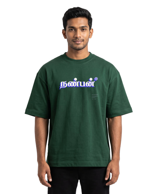 Front view of male model wearing NANBAN oversized graphic t-shirt in bottle green in a studio setting.