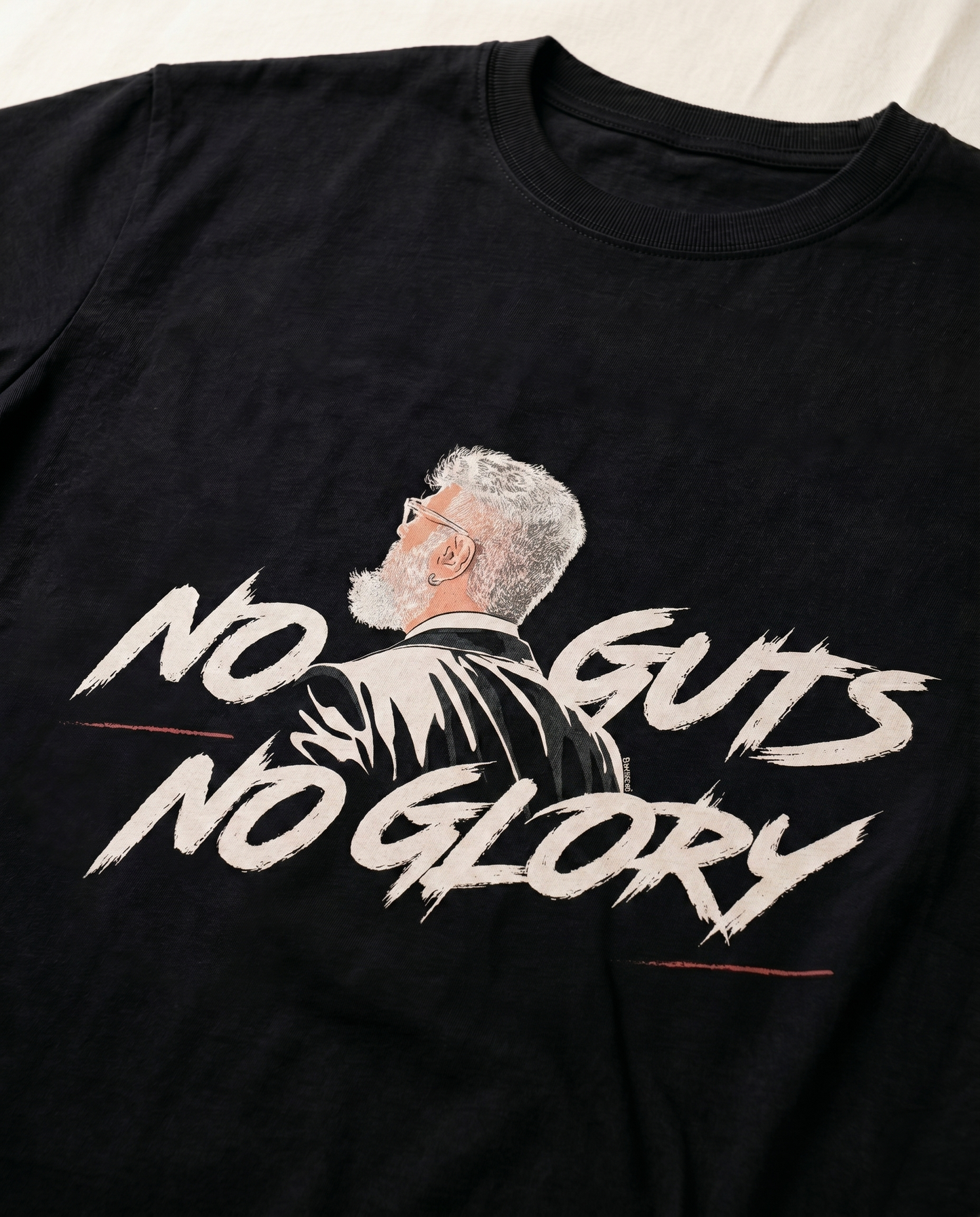 Close-up view of the NO GUTS NO GLORY front graphic print highlighting typography and premium print quality on a black men's regular-fit t-shirt.
