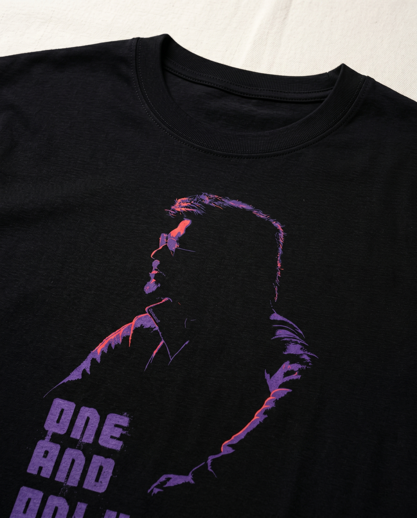 Close-up detail of NE AND ONLY Superstar inspired artwork printed on  a black men's regular-fit t-shirt.
