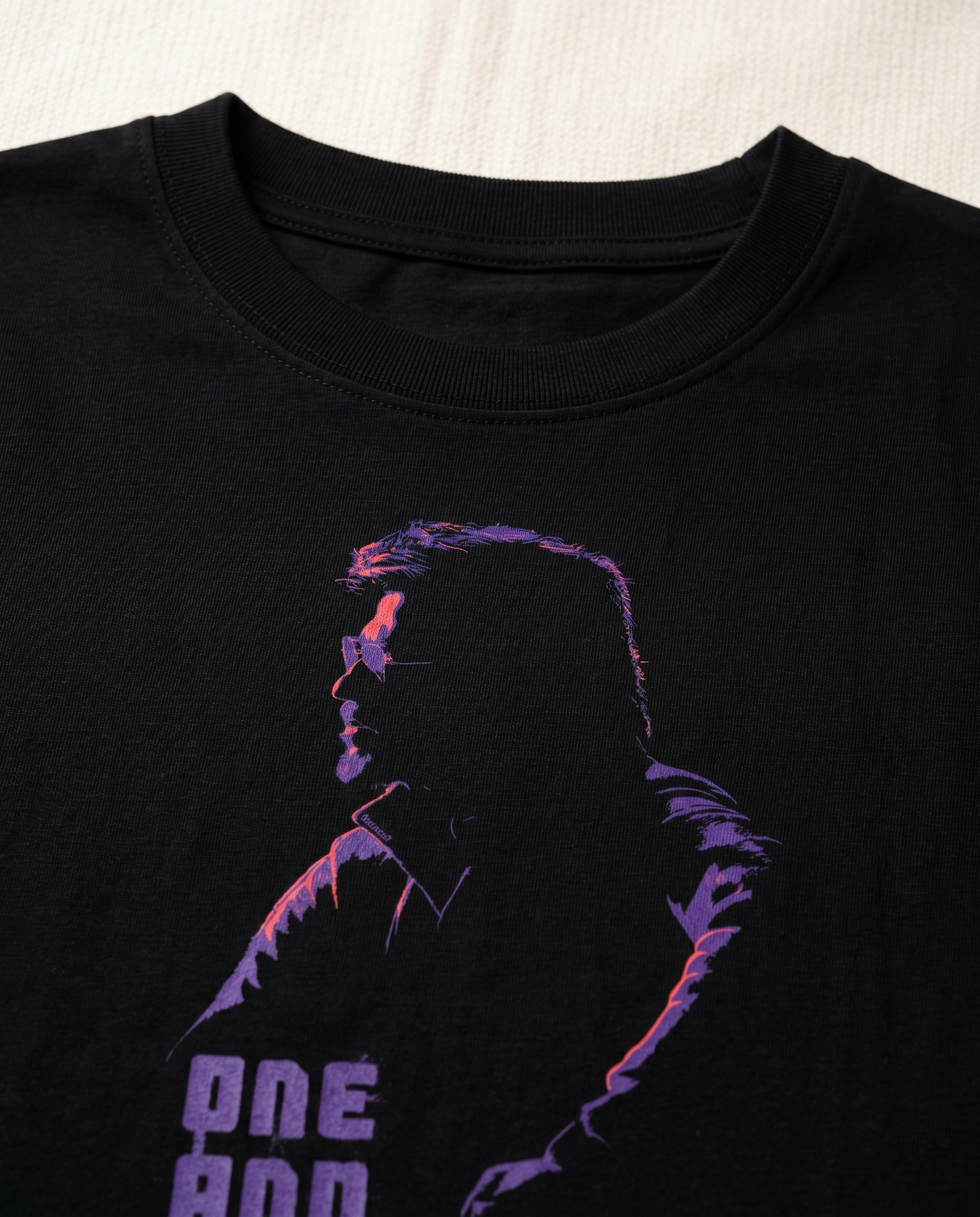 Close-up detail of ONE AND ONLY Superstar inspired artwork printed on a black women's regular-fit t-shirt.