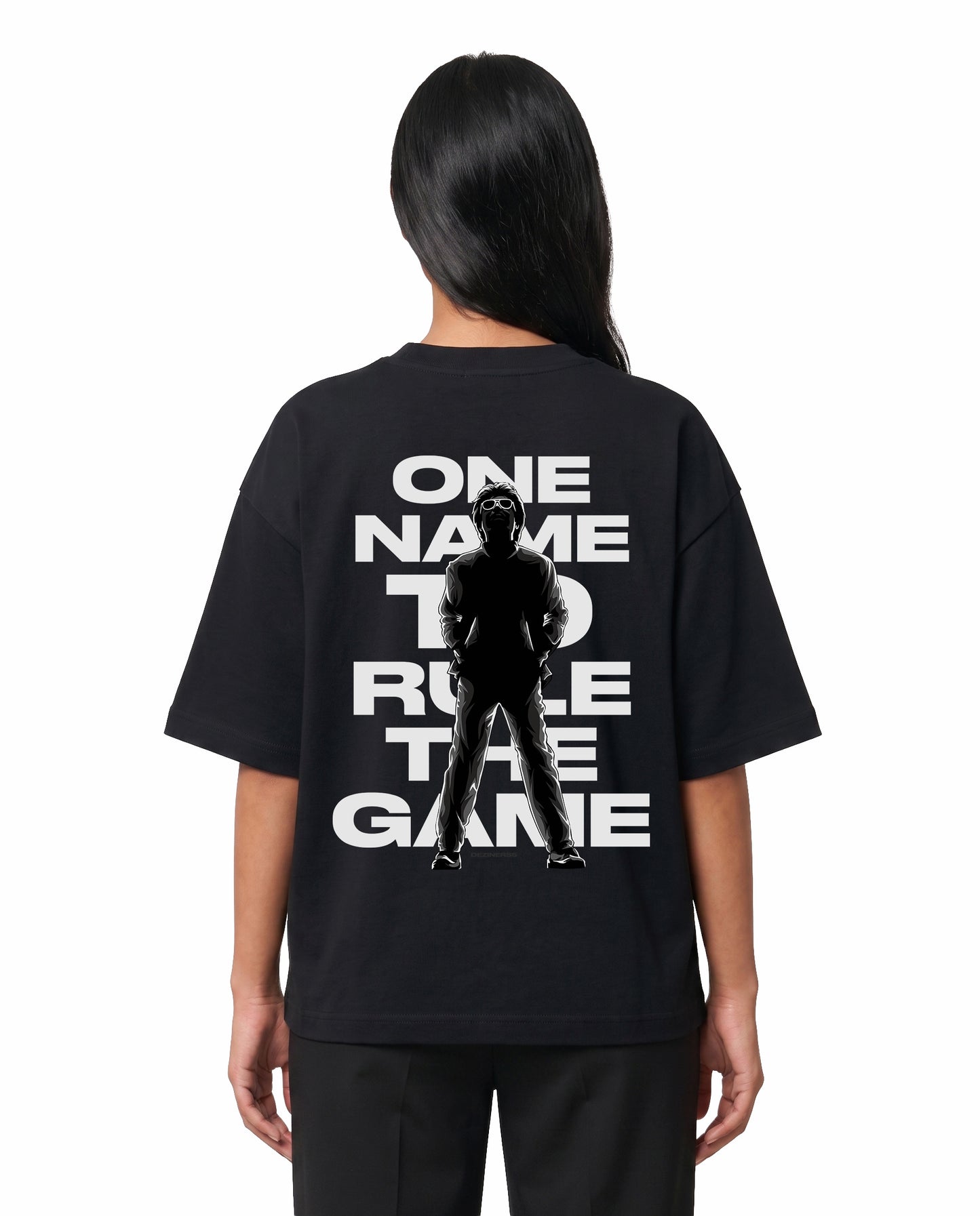 Back view of female model wearing ONE NAME unisex oversized graphic t-shirt in black in a studio setting.