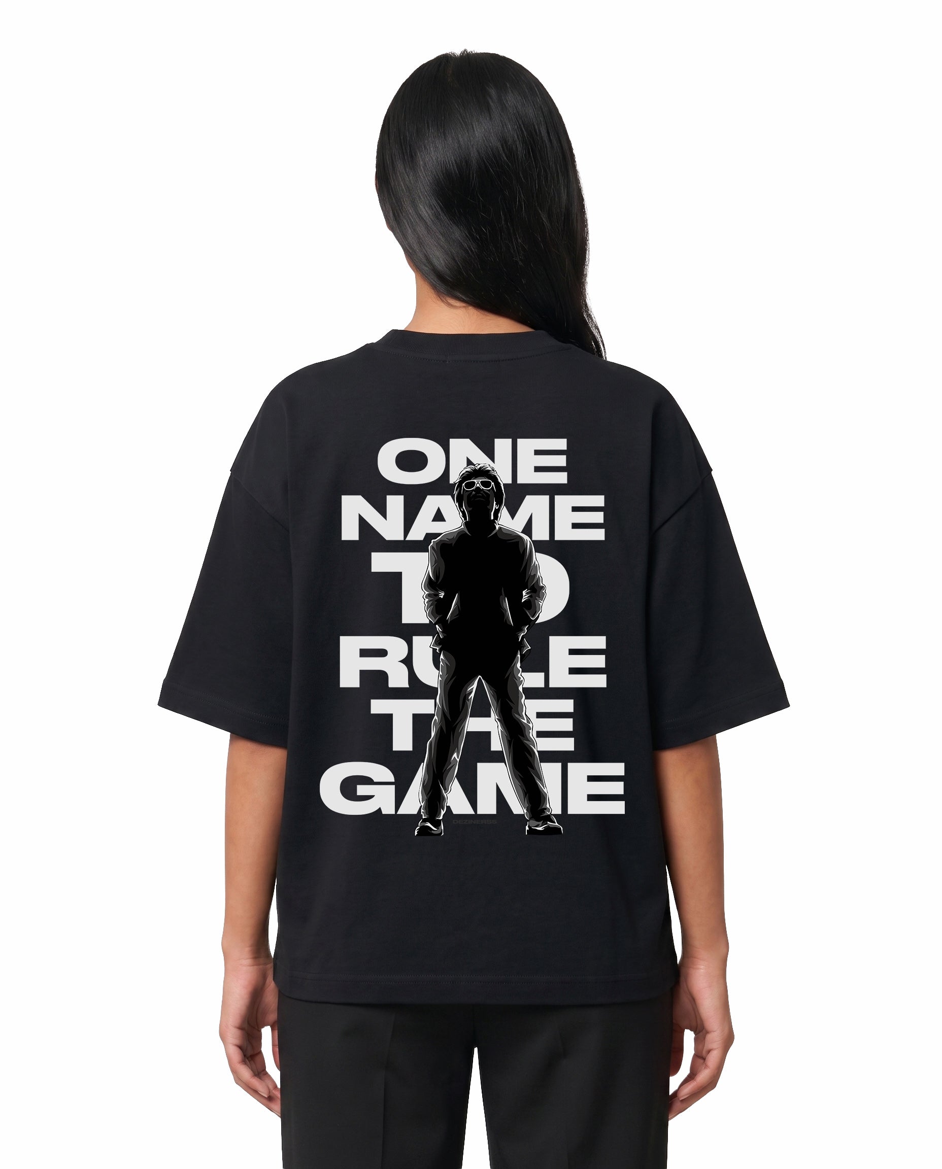 Back view of female model wearing ONE NAME unisex oversized graphic t-shirt in black in a studio setting.