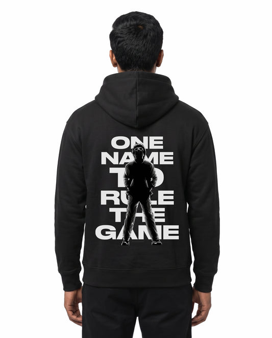 Back view of male model wearing ONE NAME unisex regular-fit hoodie in black in a studio setting.