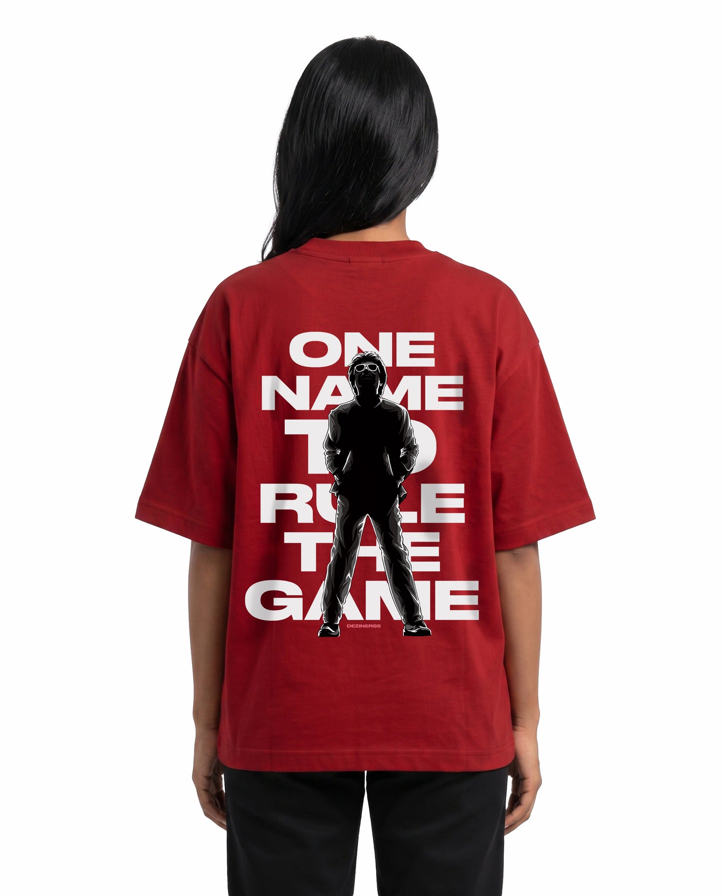 Back view of female model wearing ONE NAME unisex oversized graphic t-shirt in red in a studio setting.