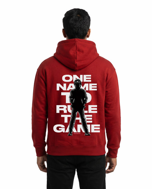 Back view of male model wearing ONE NAME unisex regular-fit hoodie in red in a studio setting.