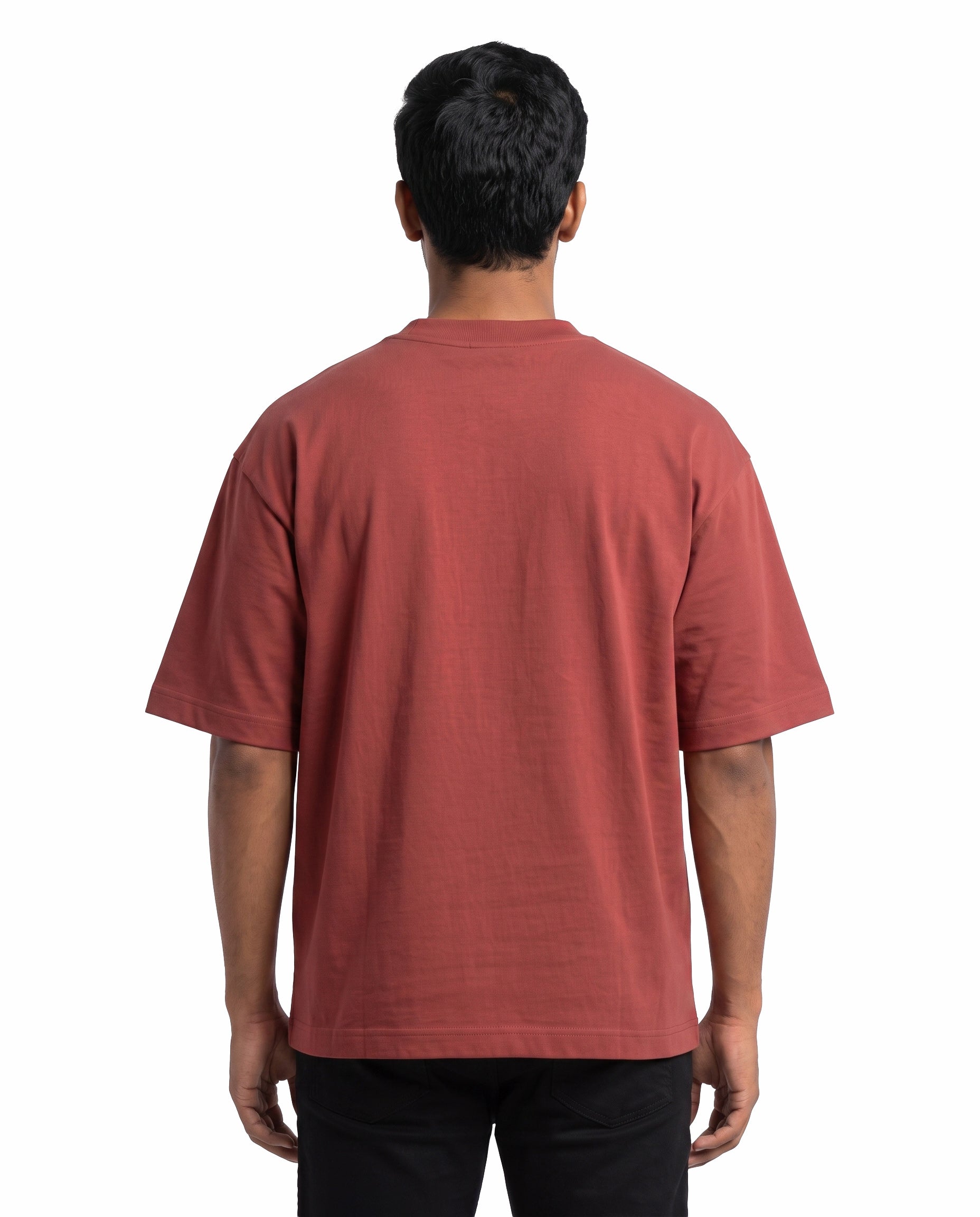 Back view of male model wearing PARTNERS IN CRIME unisex oversized graphic t-shirt in coral in a studio setting.