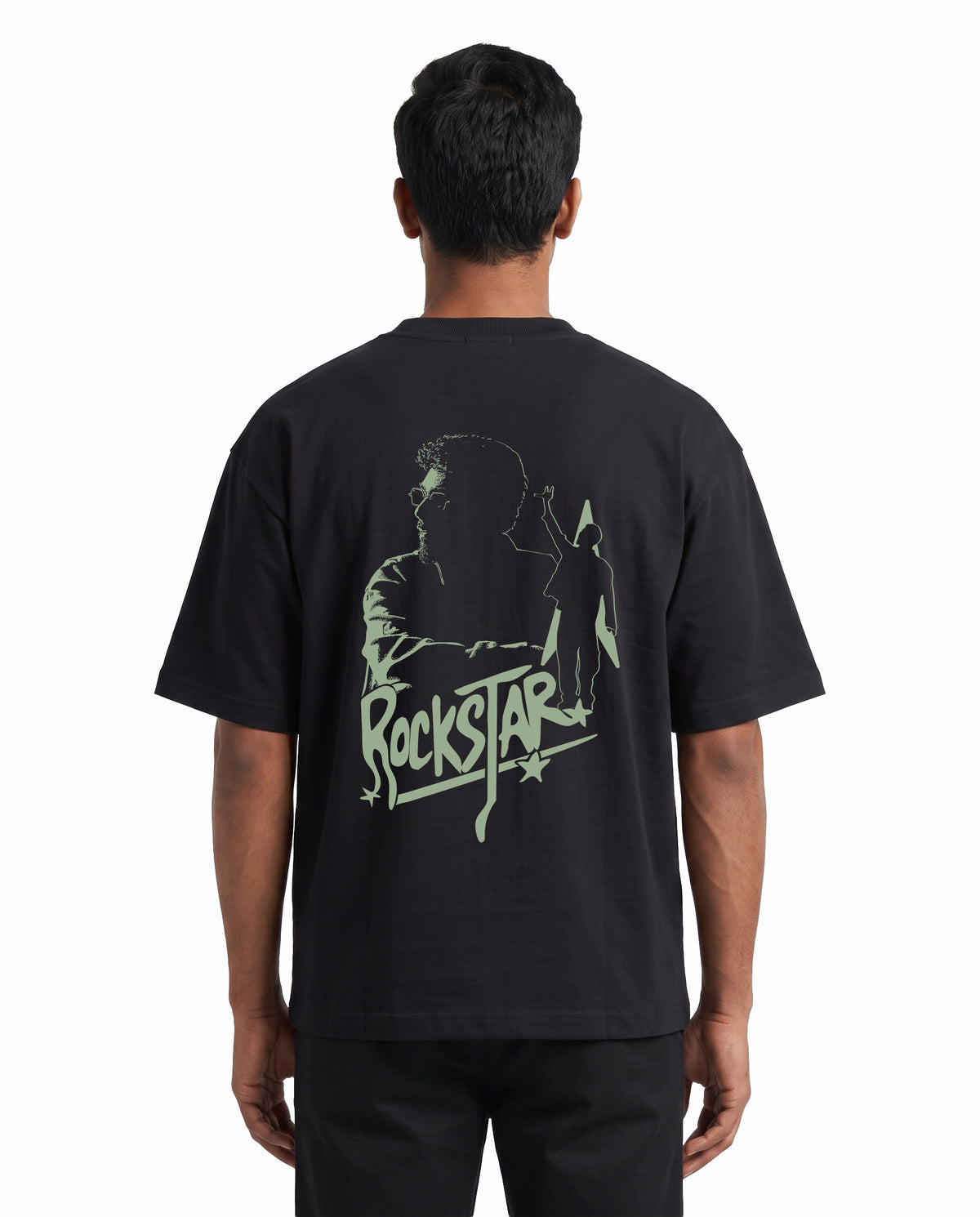 Back view of male model wearing ROCKSTAR - Unisex Oversized Graphic T-Shirt in black in a studio setting.