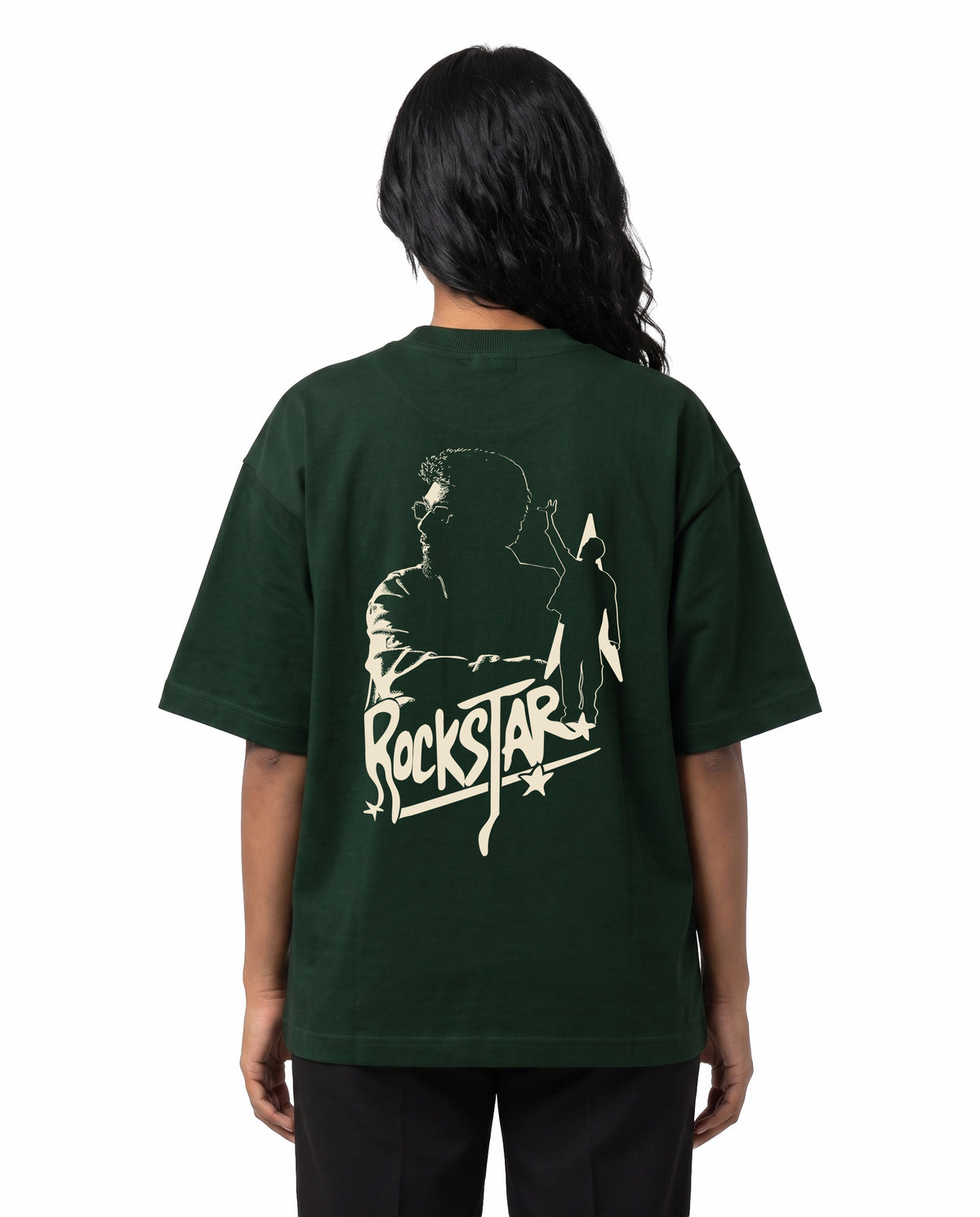 Back view of female model wearing ROCKSTAR - Unisex Oversized Graphic T-Shirt in bottle green in a studio setting.