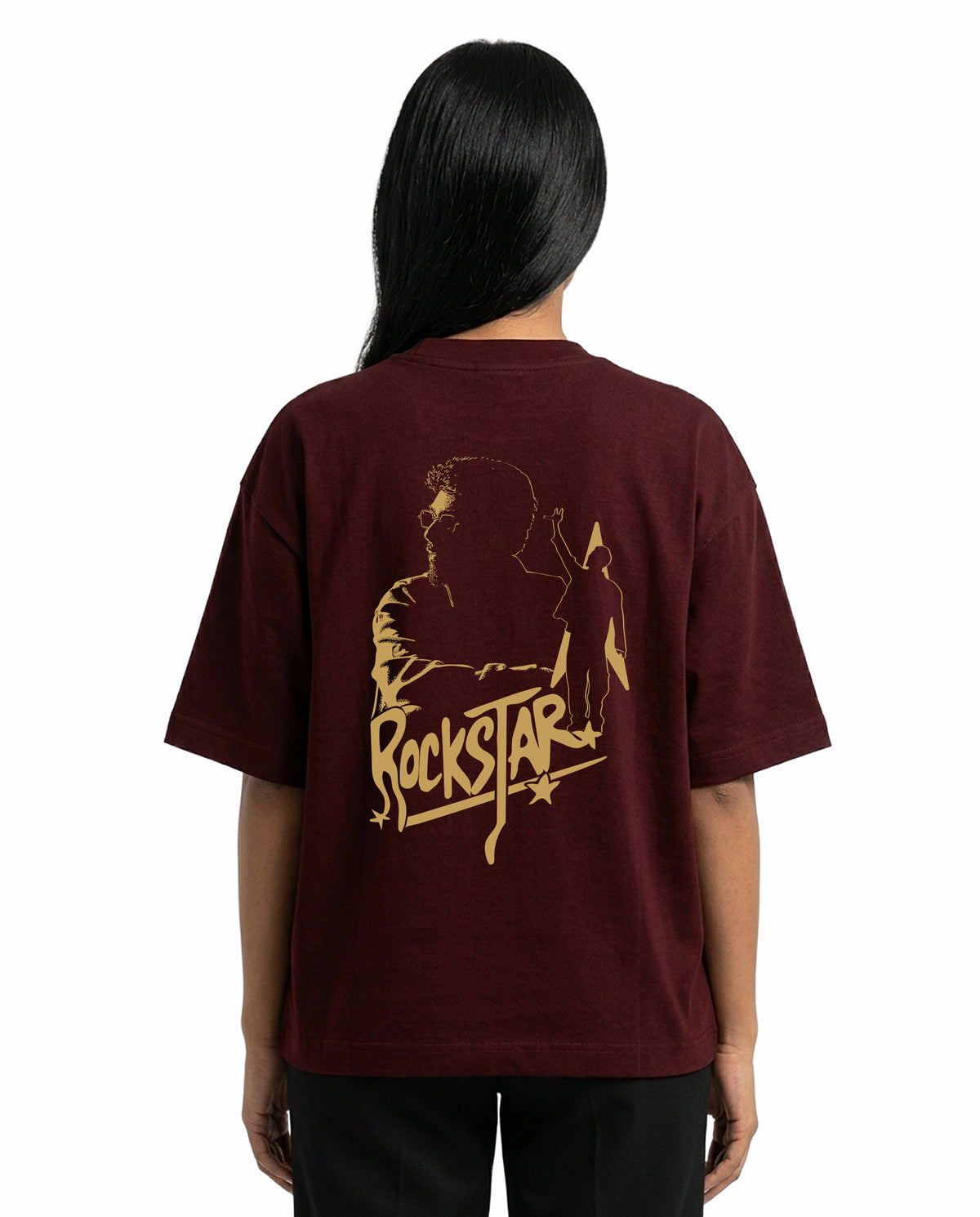 Back view of female model wearing ROCKSTAR - Unisex Oversized Graphic T-Shirt in maroon in a studio setting.