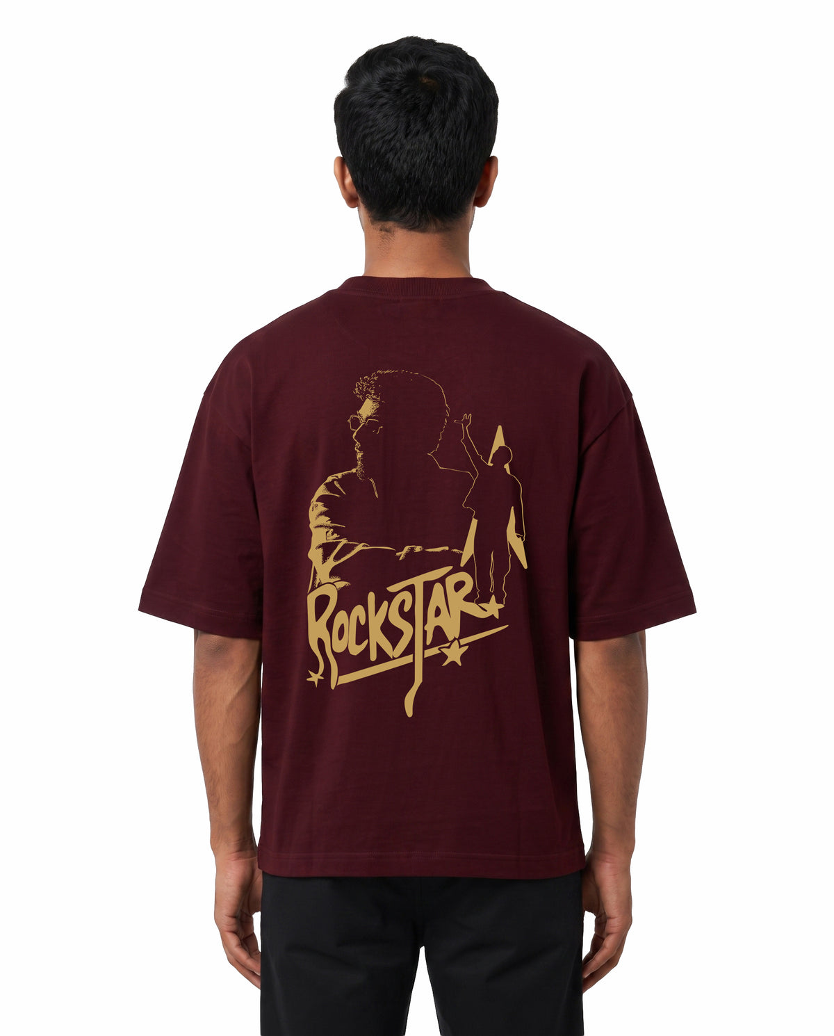 Back view of male model wearing ROCKSTAR - Unisex Oversized Graphic T-Shirt in maroon in a studio setting.