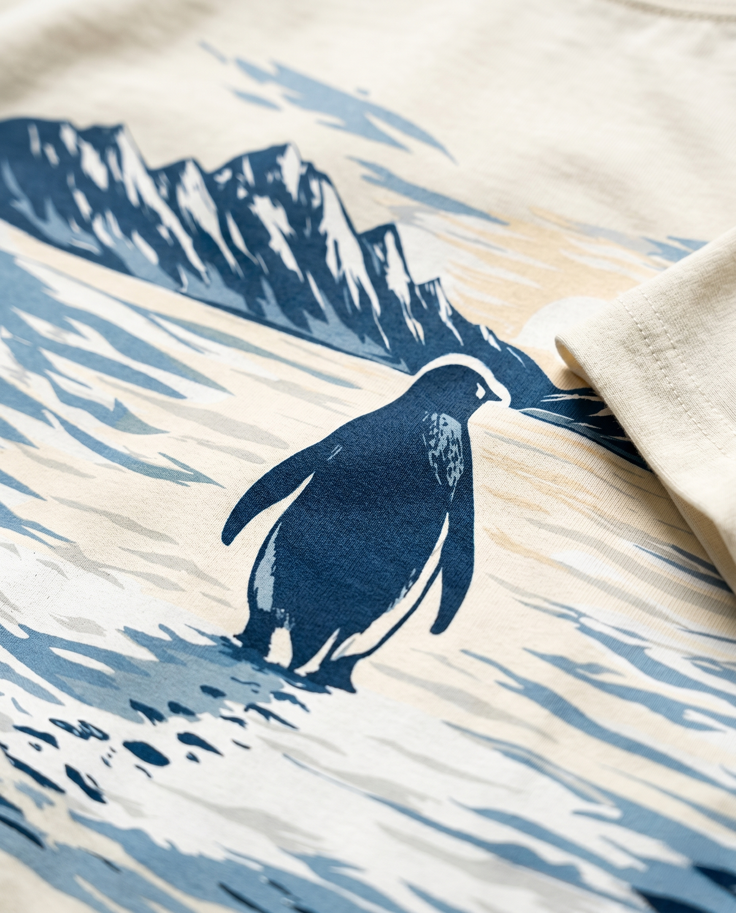 Macro detail of the SOLITUDE - unisex oversized graphic t-shirt in off-white showing premium DTG print quality, penguin illustration detail and heavyweight cotton texture.