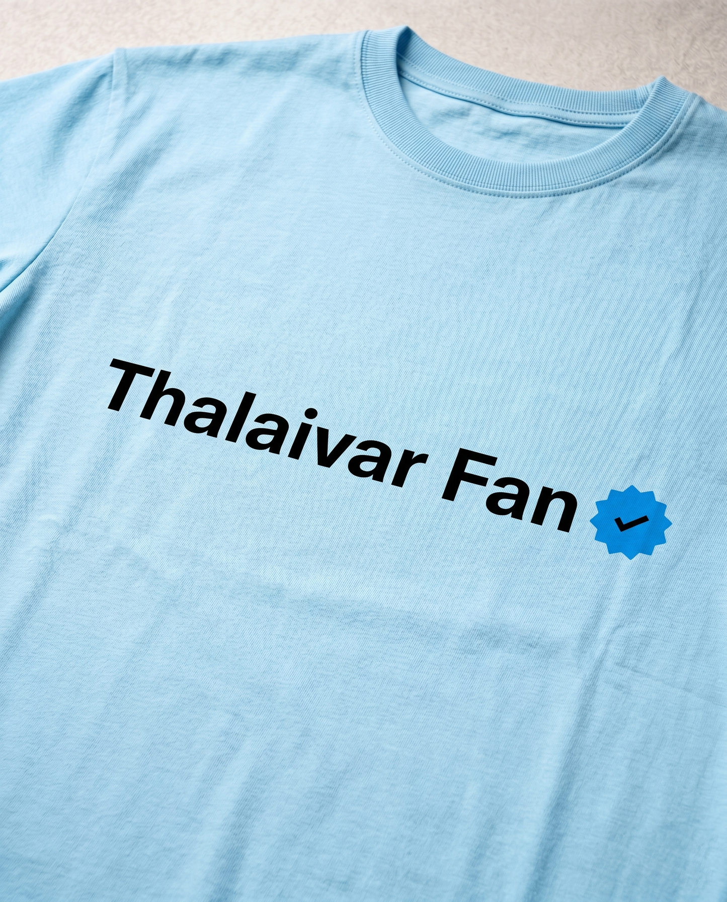 Close-up view of the THALAIVAR FAN VERIFIED front graphic print on a Baby Blue men's regular-fit t-shirt, showcasing bold typography, checklist elements, and premium print quality.