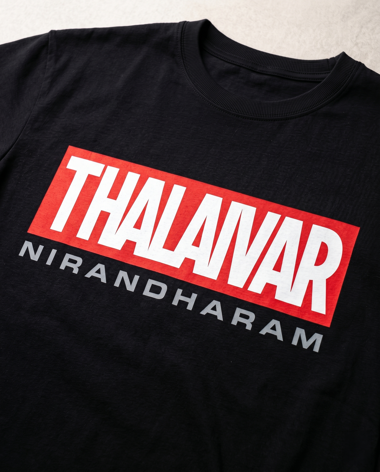 Close-up print detail of THALAIVAR NIRANDHARAM Superstar tribute artwork on black regular fit t-shirt.